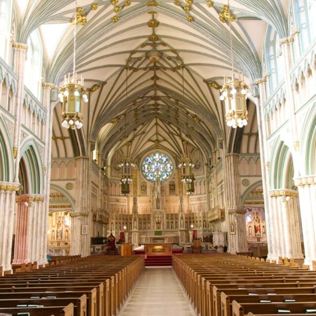 Elegant church interior featuring high vaulted ceilings, intricate woodwork, and beautiful stained glass windows, creating a peaceful and majestic atmosphere. Perfect for worship and reflection.