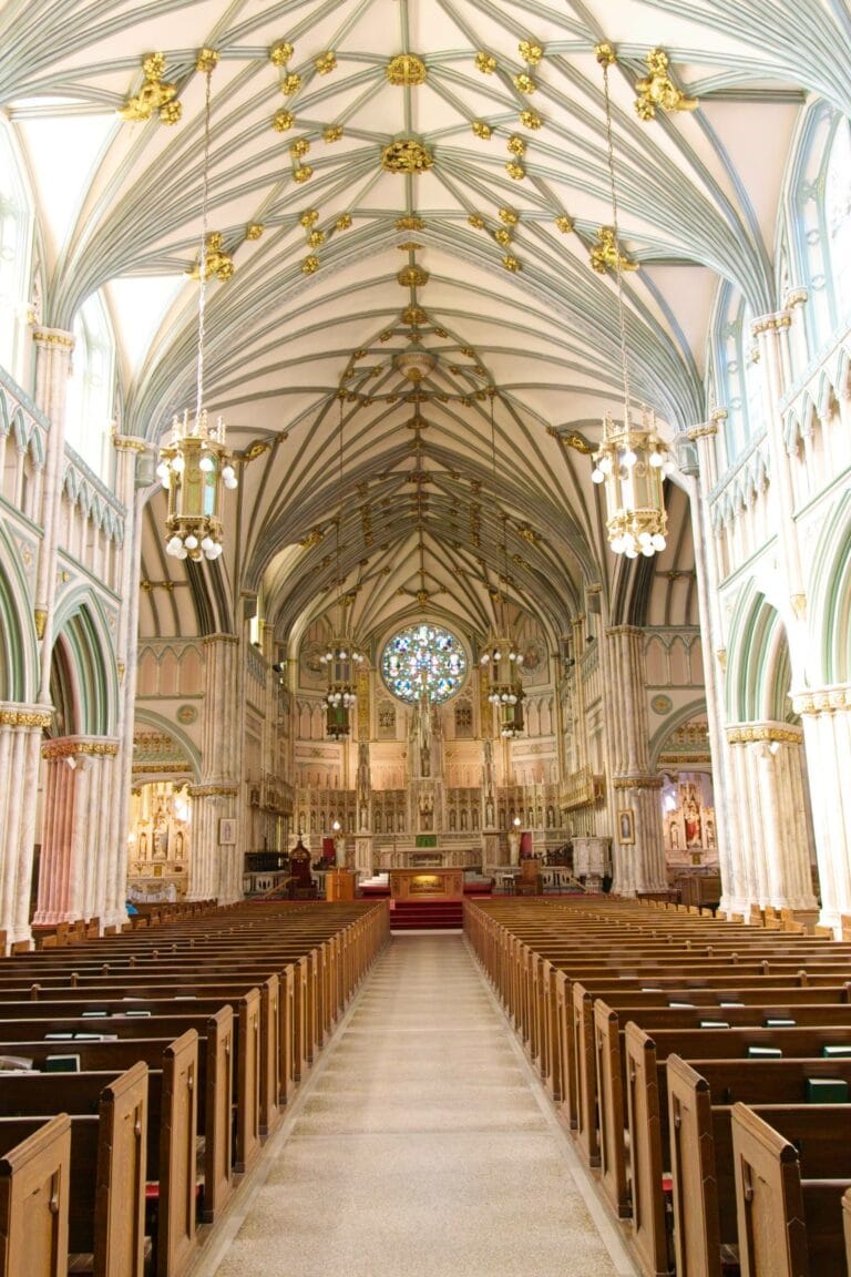 Elegant church interior featuring high vaulted ceilings, intricate woodwork, and beautiful stained glass windows, creating a peaceful and majestic atmosphere. Perfect for worship and reflection.